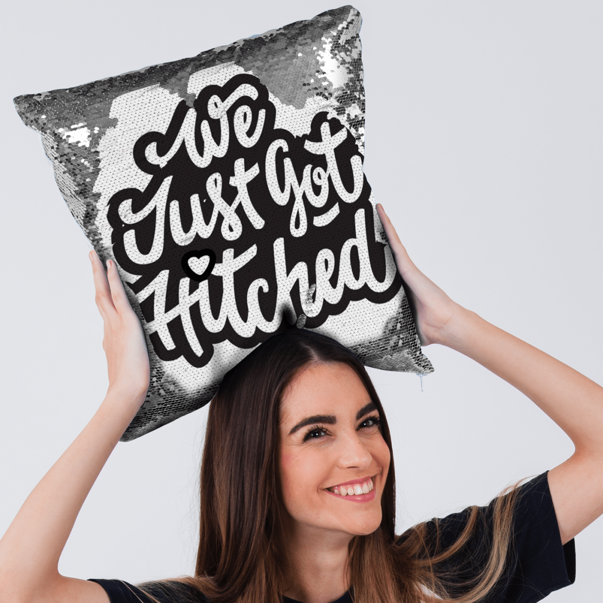 Qstomize.com - Personalize Your Pillow with Custom Reversible Sequin Design Young woman joyfully holds We Just Got Hitched pillow, celebrating love and weddings.